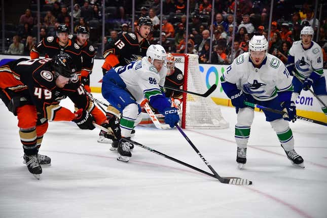 Mar 19, 2023; Anaheim, California, USA; Vancouver Canucks left wing Andrei Kuzmenko (96) plays for the puck against Anaheim Ducks left wing Max Jones (49) during the third period at Honda Center.