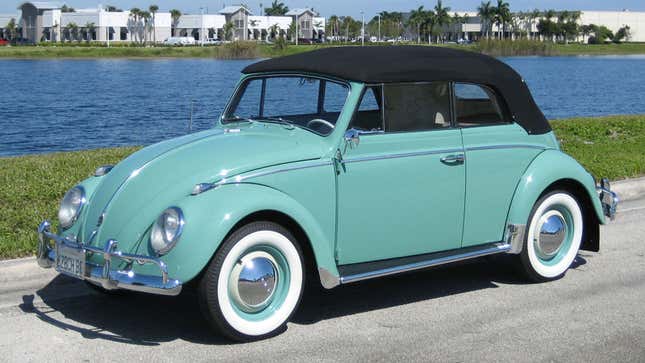 A photo of a teal VW Beetle with a black convertible roof. 