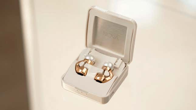 The gold Nova H1 Audio Earrings in their jewelry box-shaped charging case.