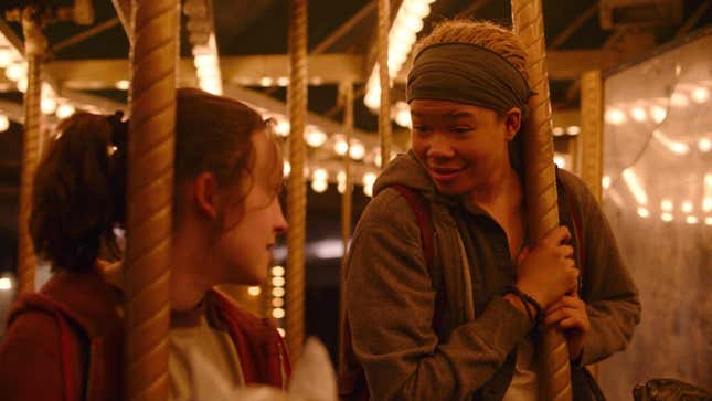 Ellie and Riley look at each other while riding a carousel in HBO's The Last of Us.