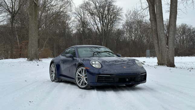 a blue 2023 porsche 911 carrera on a snow-covered road in michigan