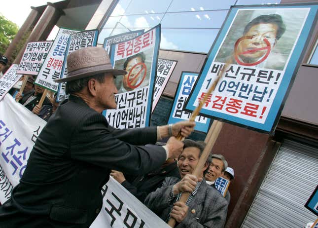 A conservative protester hits a portrait of Kim Yong-chul, a whistleblower and former lawyer for Samsung Group who claimed that the conglomerate created huge slush funds, during a pro-Samsung rally in Seoul April 17, 2008.