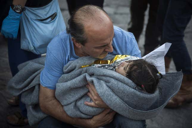 A man tries to warm up a child. Wednesday, Oct. 28, 2015