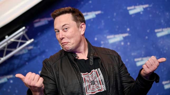 Elon Musk is shown making a funny face and giving two thumbs up.