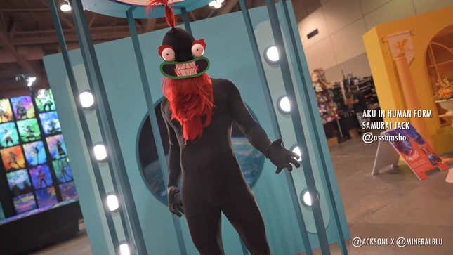 A cosplayer dressed as Aku from Samurai Jack stands with their hands outstretched.
