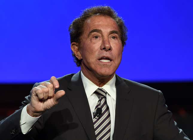 Portrait of Steve Wynn speaking on stage against a blue background.