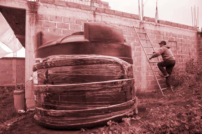 Edgar Serralde uses a ladder to climb on to his rooftop on the day a large water cistern, left, was delivered to his home in Mexico City's borough Xochimilco. With the help of Isla Urbana the 37-year-old lettuce farmer upgraded his rain harvesting system.