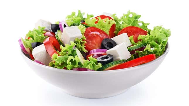 Salad in bowl with tomatoes, olives, onion, cheese