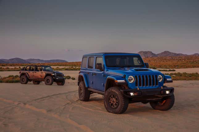 Two Jeep SUVs parked on sand
