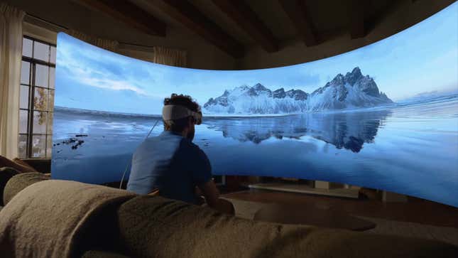 Un hombre que usa los auriculares Vision Pro de Apple mira una pantalla virtual ancha superpuesta en su sala de estar.