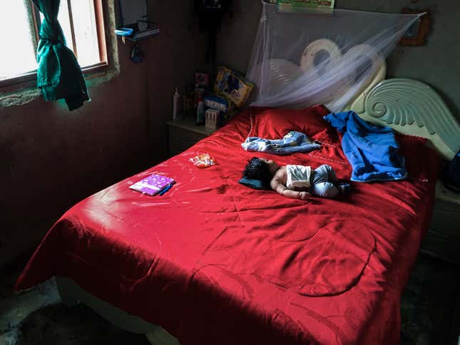 A baby sleeps while his parents work in the marijuana field.