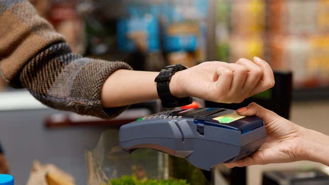 A woman uses an Apple Watch to pay for her groceries