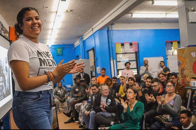 Ilona Duverge speaks in front of a crowd of people including fellows with Movement School and Rep. Alexandria Ocasio-Cortez