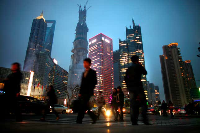 Commuters pass Shanghai Tower in the evening.