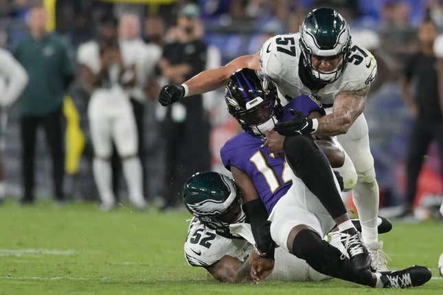 Aug 12, 2023; Baltimore, Maryland, USA;  Baltimore Ravens quarterback Anthony Brown (12) is tackled from behind by Philadelphia Eagles linebacker Zach Cunningham (52) and =inebacker Ben VanSumeren (57) during the second half at M&amp;amp;T Bank Stadium.