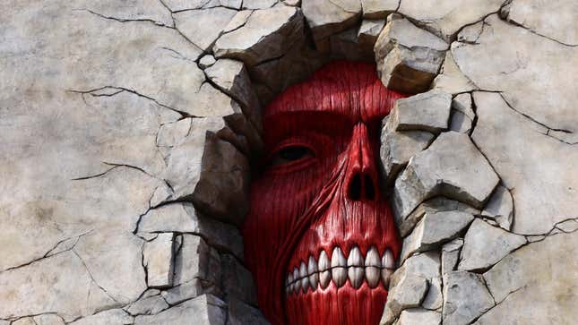 An image of the Attack on Titan attraction at Universal Japan featuring a larger than life size skinless face peering through a giant hole in a concrete wall