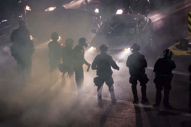  Smoke and tear gas fill the air around trapped drivers as police advance upon demonstrators after a rally by President Donald Trump at the Phoenix Convention Center on August 22, 2017, in Phoenix, Arizona. An earlier statement by the president that he was considering a pardon for Joe Arpaio, the former sheriff of Maricopa County who was convicted of criminal contempt of court for defying a court order in a case involving racial profiling, has angered Latinos and immigrant rights, advocates.