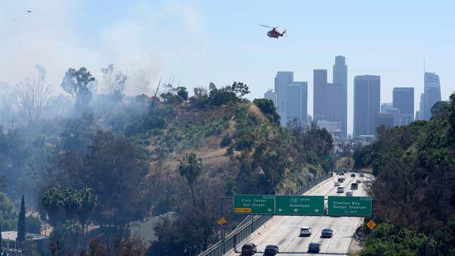 A Los Angeles City Fire Department helicopter gets ready to drop water on a brush fire that broke out in the Elysian Park area on July 7, 2023, in Los Angeles.