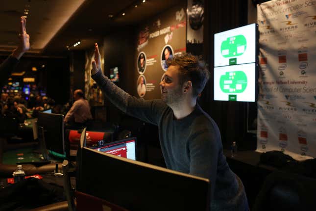 Daniel McAuley gets a high-five after finishing his last hand of poker in the tournament.