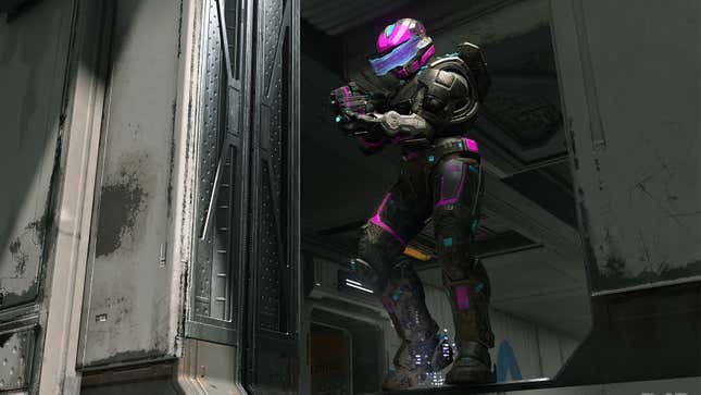 A Spartan wearing black and pink armor holds an assault rifle on the Recharge map in Halo Infinite.