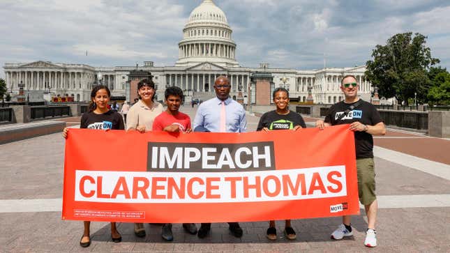 Executive Director of MoveOn.org Rahna Epting (far left), Rep. Jamaal Bowman (D-NY) (C), Tamara Brummer and Matthew Witten hold up an “Impeach Clarence Thomas” banner outside of the US Capitol after a demonstration where MoveOn.org delivered over 1 million signatures calling for Congress to immediately investigate and impeach Clarence Thomas at the US Supreme Court on July 28, 2022 in Washington, DC. 