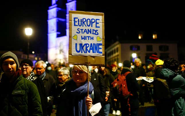 Protestors holding a sign that reads "Europe standing with Ukraine"