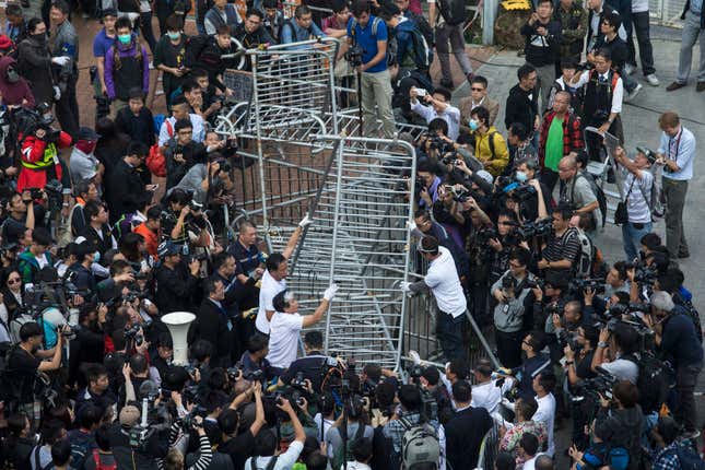 Building employees of the Citic Tower in Admiralty, the Umbrella Movement’s main protest site, remove barricades.