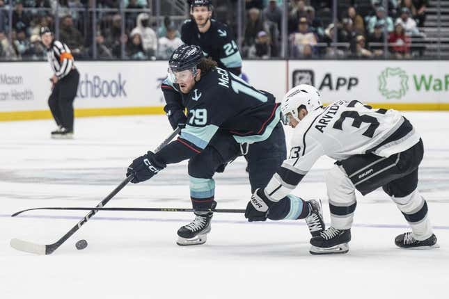 Apr 1, 2023; Seattle, Washington, USA; Seattle Kraken forward Jared McCann (19) has the puck knocked away by Los Angeles Kings forward Viktor Arvidsson (33) during the third period at Climate Pledge Arena.