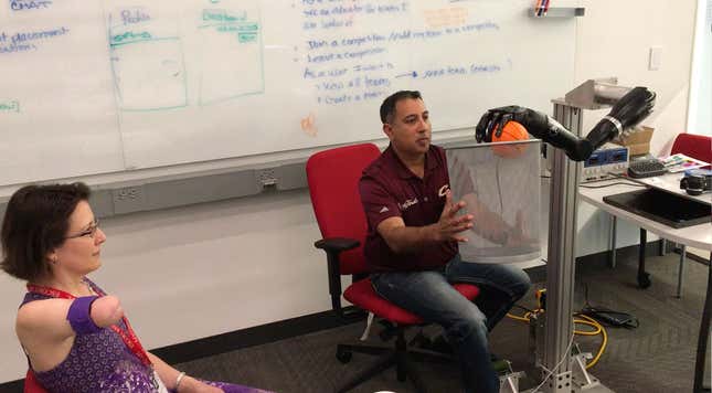 Melissa controls DARPA’s advanced prosthetic limb, dunking a foam basketball into a basket held by her surgeon, Ajay Seth.