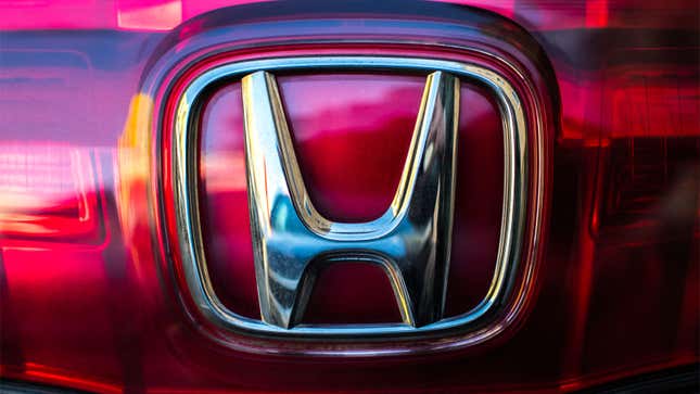 A photo of a Honda 'H' badge on the front of a car. 