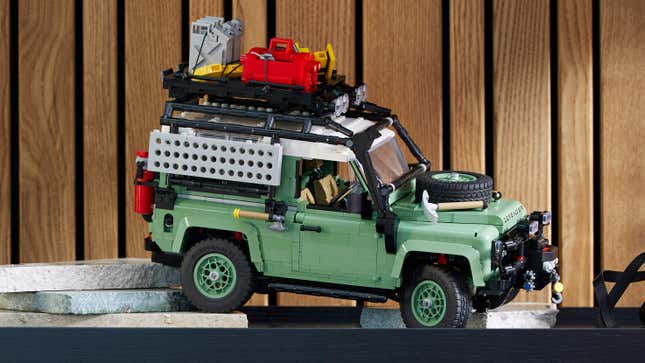 A side shot of the Lego Land Rover Defender 90, sitting on a shelf, equipped with outdoor adventure accessories.