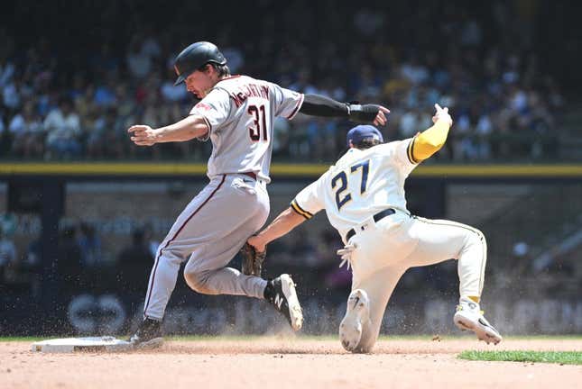 Jun 21, 2023; Milwaukee, Wisconsin, USA; Arizona Diamondbacks right fielder Jake McCarthy (31) slides in safely ahead of the tag by Milwaukee Brewers shortstop Willy Adames (27) in the fifth inning at American Family Field.