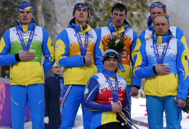 Ukraine's team, from left: Ihor Reptyukh, Vitaliy Kazakov, Olena Iurkovska, Iurii Utkin, Borys Babar and Vitaliy Lukyanenko cover their silver medals with their hands after finishing second in cross country 4x2.5km open relay at the 2014 Winter Paralympic, Saturday, March 15, 2014, in Krasnaya Polyana, Russia. The majority of Ukraine's Paralympic medalists covered their medals during medal ceremonies. (AP Photo/Dmitry Lovetsky)
