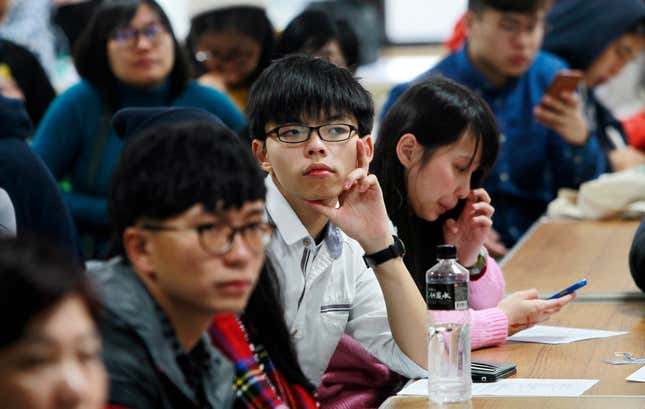 Hong Kong pro-democracy student leader Joshua Wong, center, listens to speakers during a democracy forum in Taipei, Taiwan, Jan. 14, 2016.