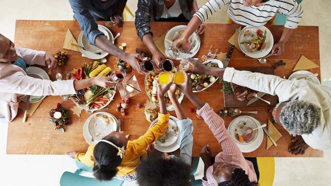 Family cheersing glasses around holiday table