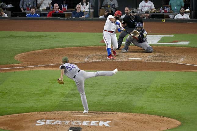 May 20, 2023; Arlington, Texas, USA; Texas Rangers catcher Sandy Leon (12) bats against Colorado Rockies relief pitcher Daniel Bard (52) during the game at Globe Life Field.