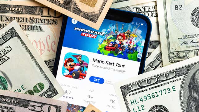 Stock image of money surrounding Mario Kart Tour app on phone