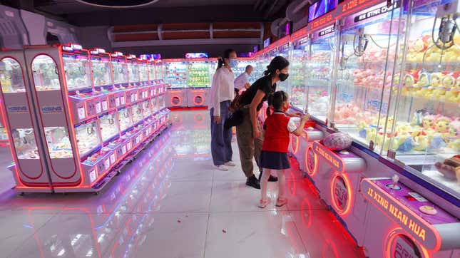 People play physical claw machine games in a shopping mall.
