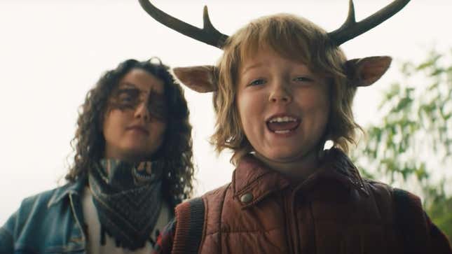 A still from Netflix's Sweet Tooth blooper reel features Stefania LaVie Owen as Bear with mask-like makeup over her eyes and Christian Convery's Gus smiling wide with antlers on top of his head.