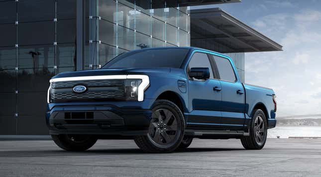 A dark blue 2023 Ford F-150 Lightning is parked in front of a glass building.