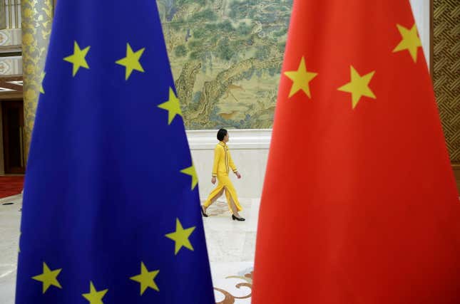 A person walks past EU and China flags