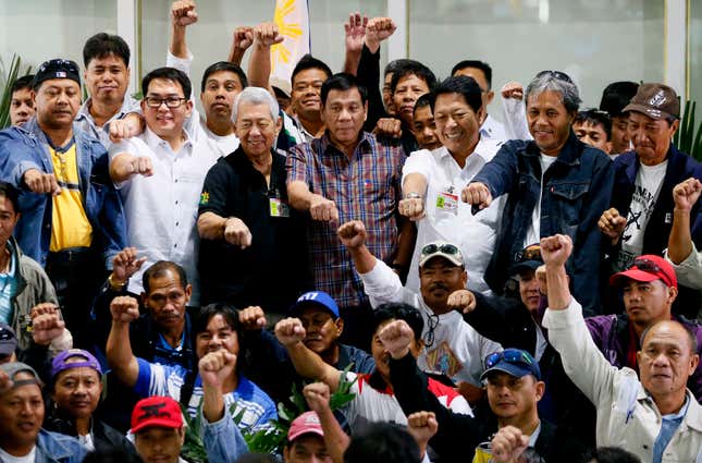 Philippine President Rodrigo Duterte poses with OFWs upon their arrival in Manila airport, Aug. 31, 2016. The workers were repatriated back to the country from Saudi Arabia.