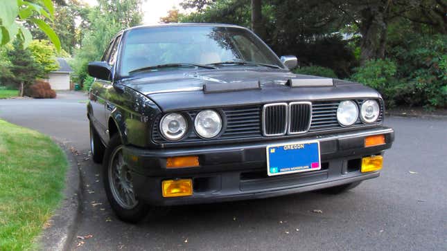 A BMW with a protective cover on the hood. 