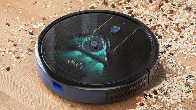 The robot vacuum moves along a hardwood floor collecting debris. 