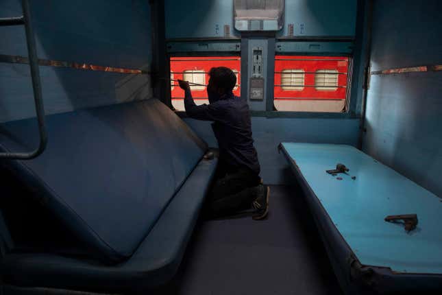 An Indian Railways employee works to convert a train coach into an isolation ward.