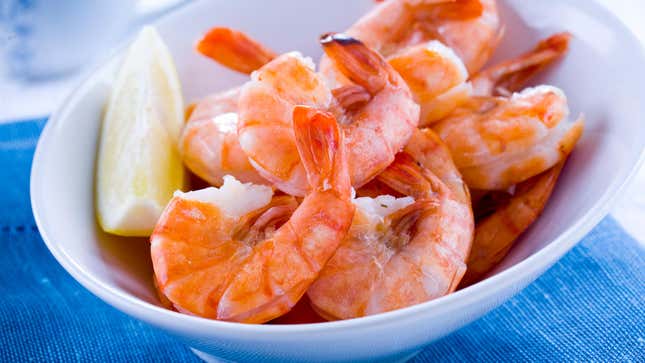 Some shrimp in a bowl with a slice of lemon