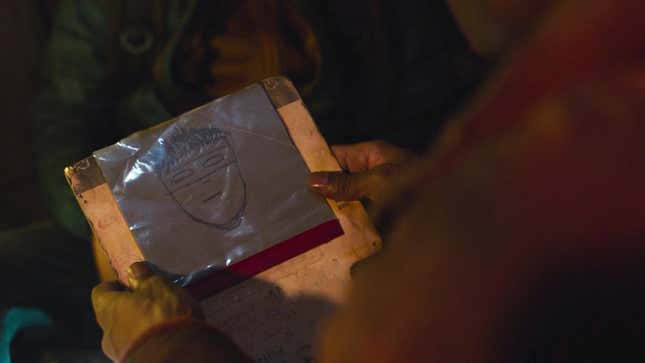 Henry holds a magnetic sketchpad on which Sam has drawn himself as a masked superhero in HBO's The Last of Us.