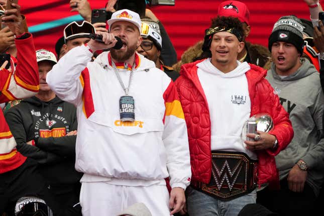Travis Kelce and Patrick Mahomes celebrate on stage during the Kansas City Chiefs Super Bowl LVII victory parade.