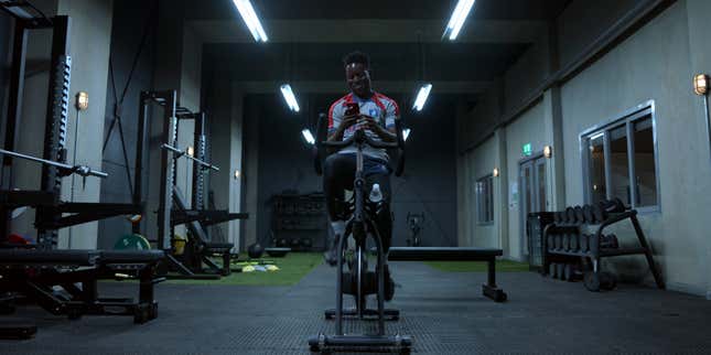 "Ted Lasso" character Sam Obisanya texting with his father while riding an exercise bike.