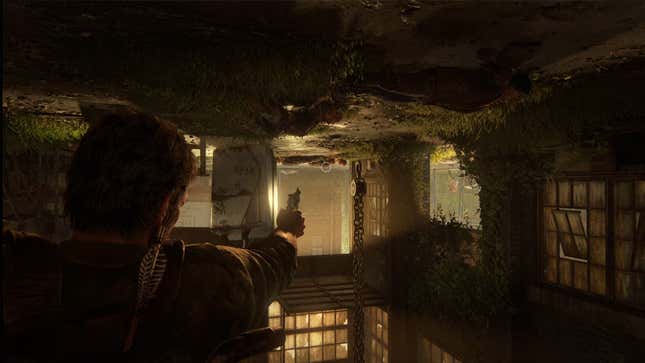 Joel hangs upside down in a garage while aiming a gun at infected enemies.